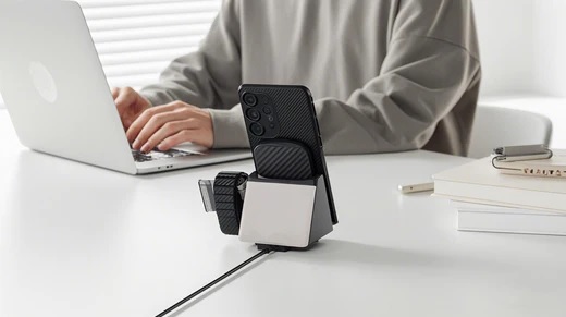 Smartphone charging with a magnetic charger on a modern desk.