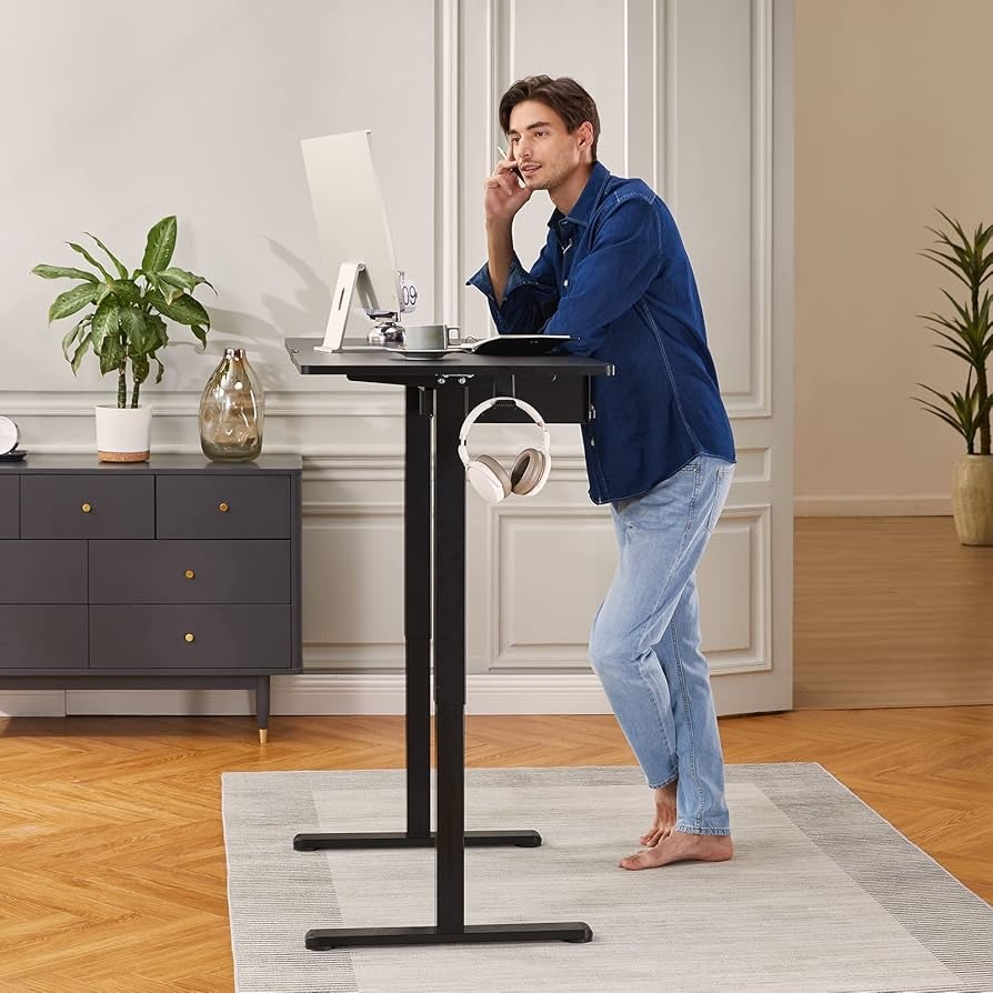 Electric adjustable sit stand desk transitioning from sitting to standing position